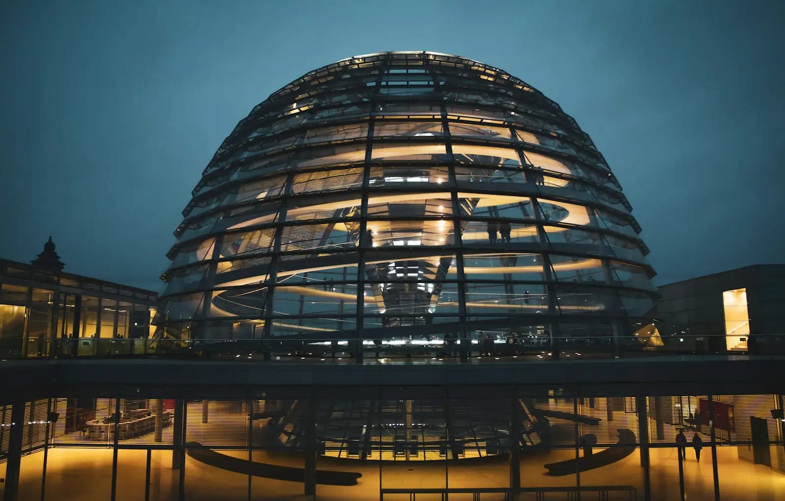 Die gläserne Kuppel des Reichstagsgebäudes in Berlin, in der Dämmerung von innen beleuchtet
