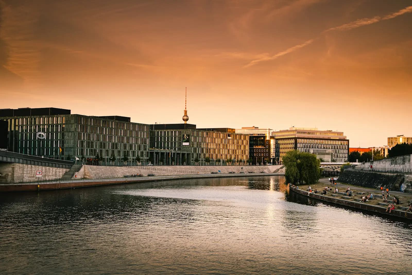 Das Berliner Regierungsviertel an der Spree im Abendlicht, dahinter der Fernsehturm